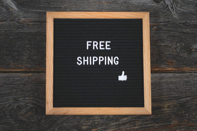 black board with text saying free shipping and a thumbs-up