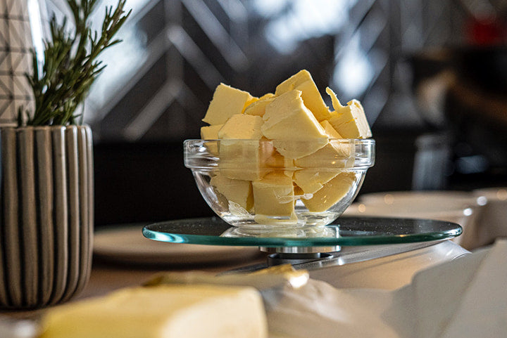 Cannabis infused butter in a glass bowl on a counter.