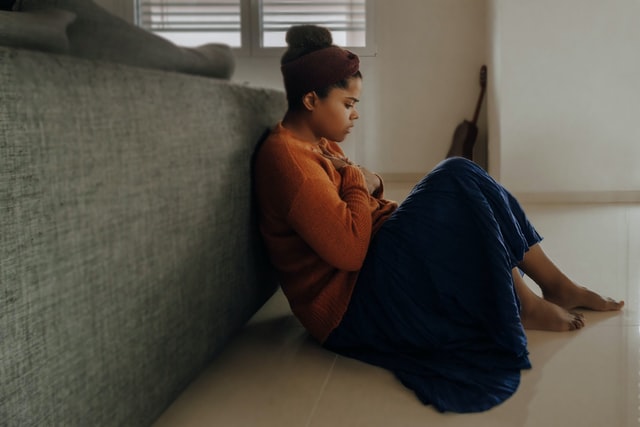 Woman sitting on the floor having an anxiety attack