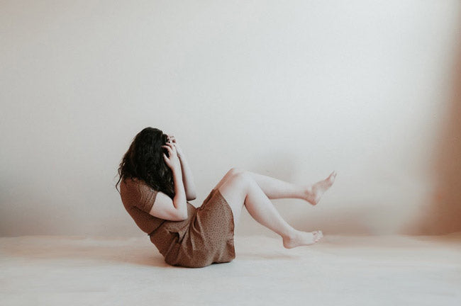 stressed woman huddled on the floor